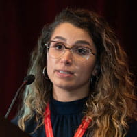 Farah Allouch is seen speaking at a podium during a presentation at EPI|Lifestyle 2023 in Boston, MA.