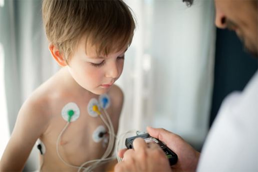 doctor adjusting ECG monitor on child