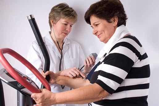 female patient on exercise equipment with female doctor