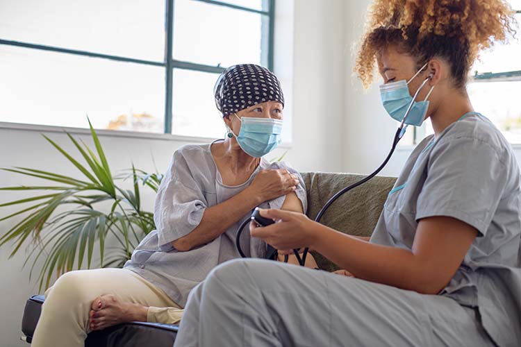 patient sitting on couch getting vitals taken