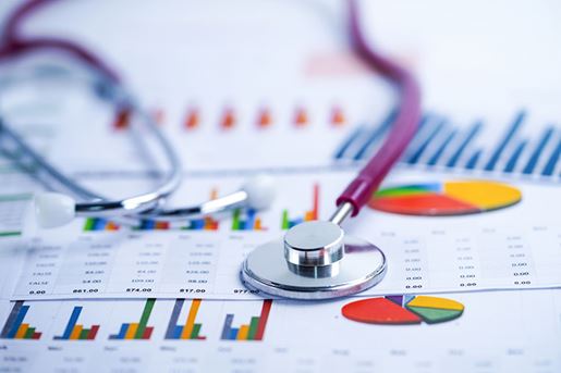 stethoscope and U.S. dollar banknotes on chart or graph paper