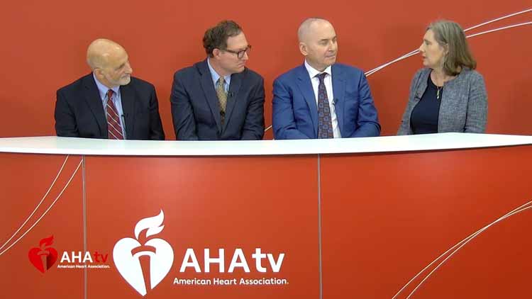Three men and a women talking at a news desk during AHA tv